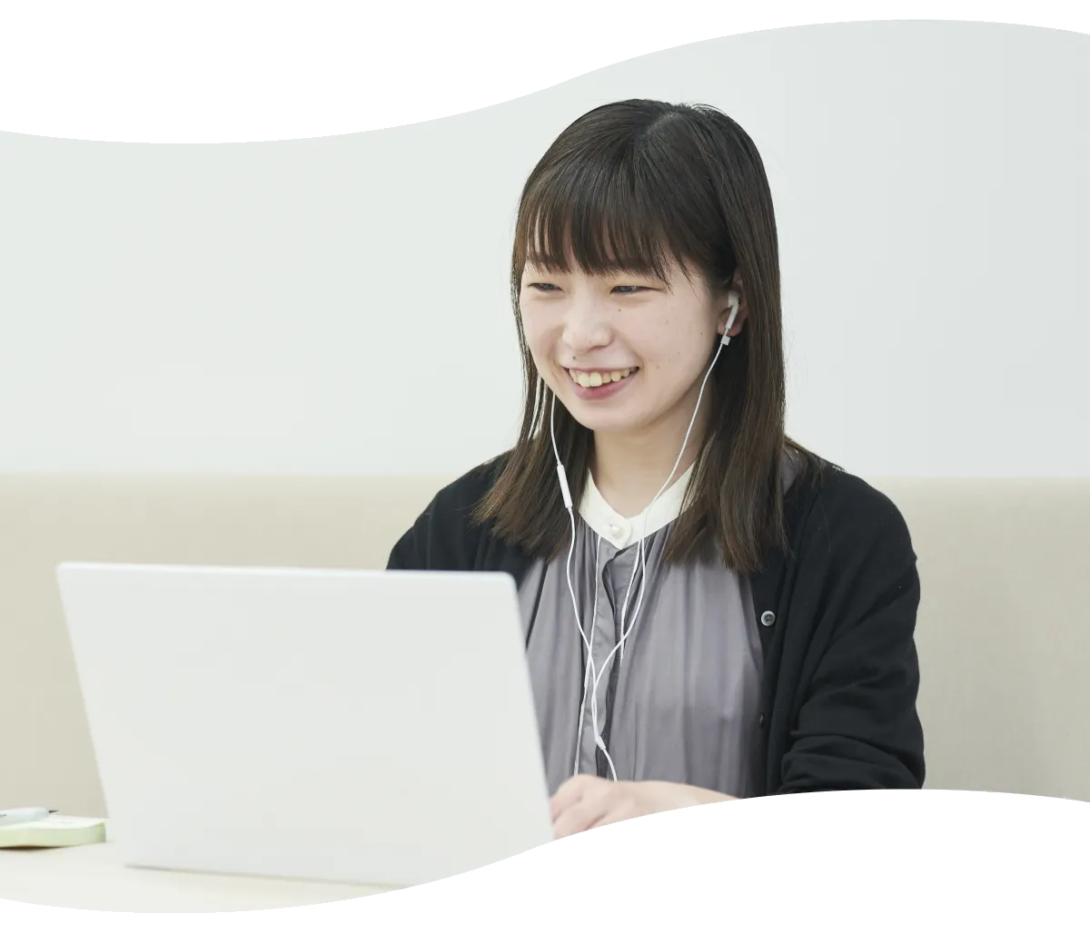 イヤホンを着けノートパソコンでオンライン打ち合わせをするM.M