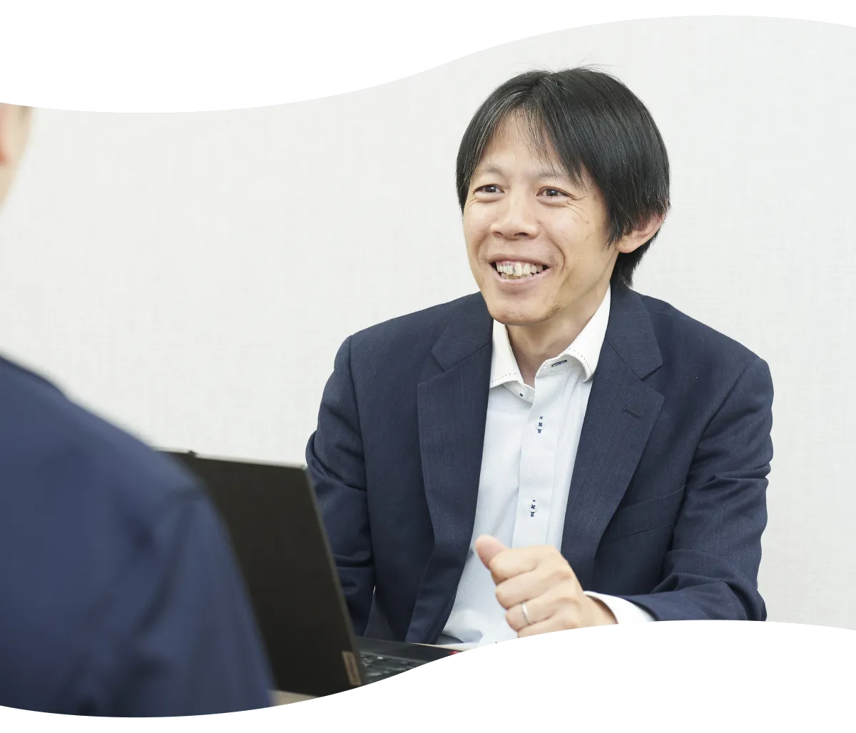 ノートパソコンを前に笑顔で語り合うY.K